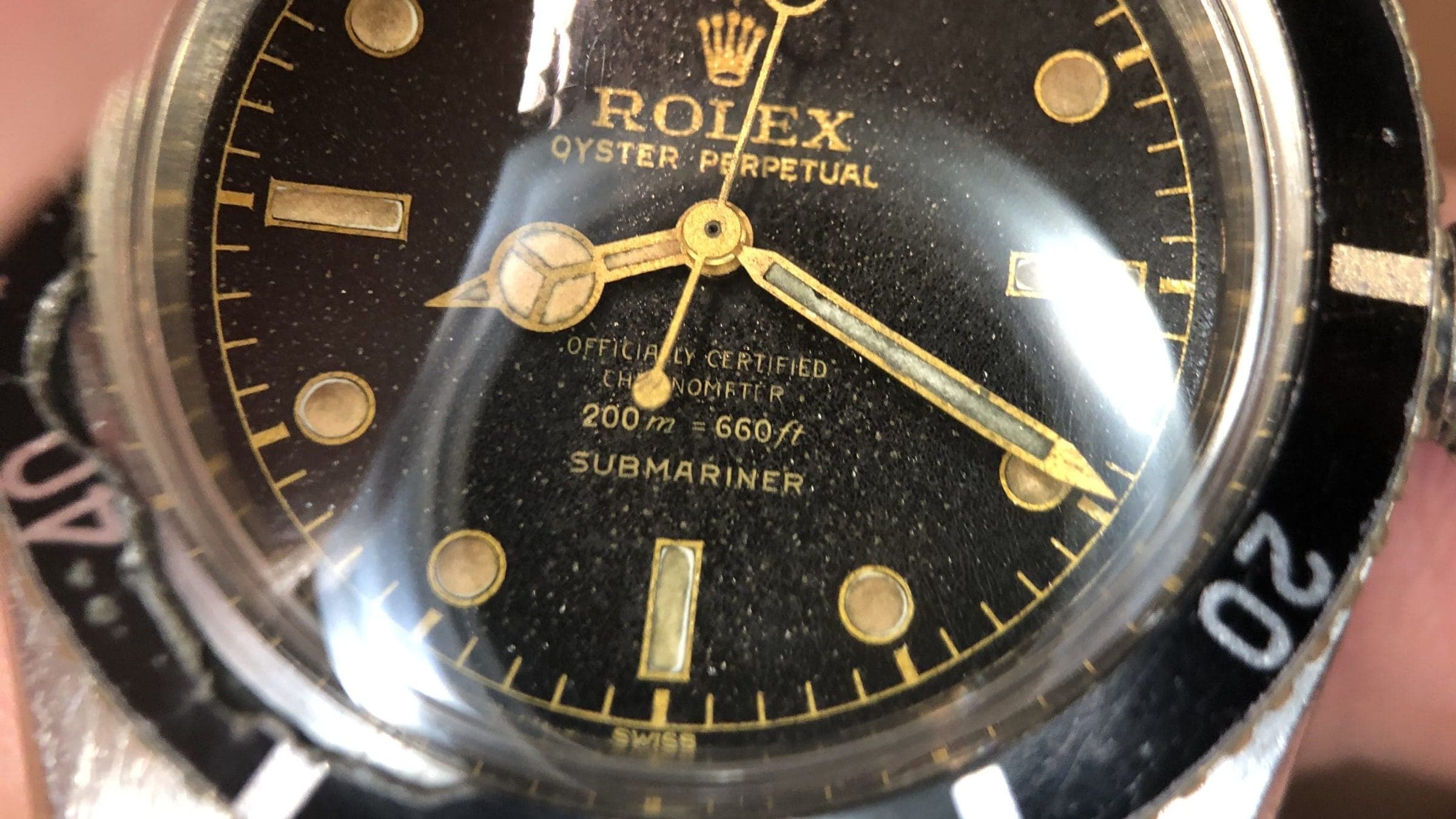 Close-up of a vintage Rolex gilt dial showing gold text and markers with natural aging