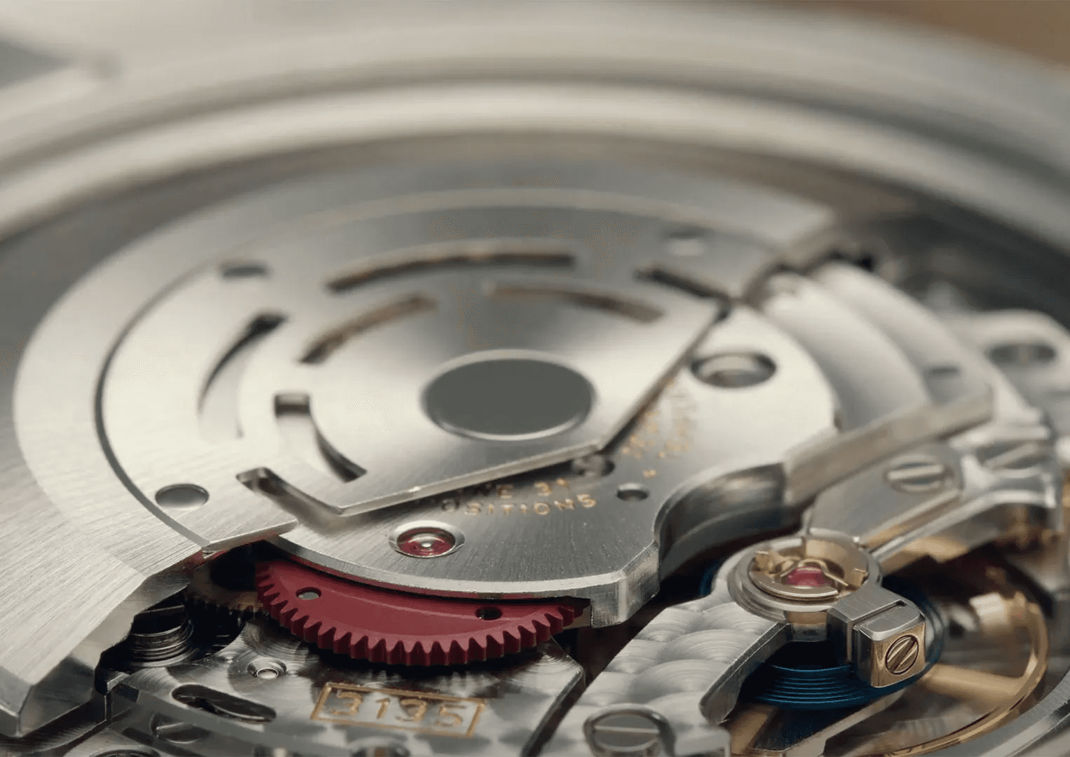 Close-up of Rolex Perpetual rotor with red engraving showing the automatic winding mechanism