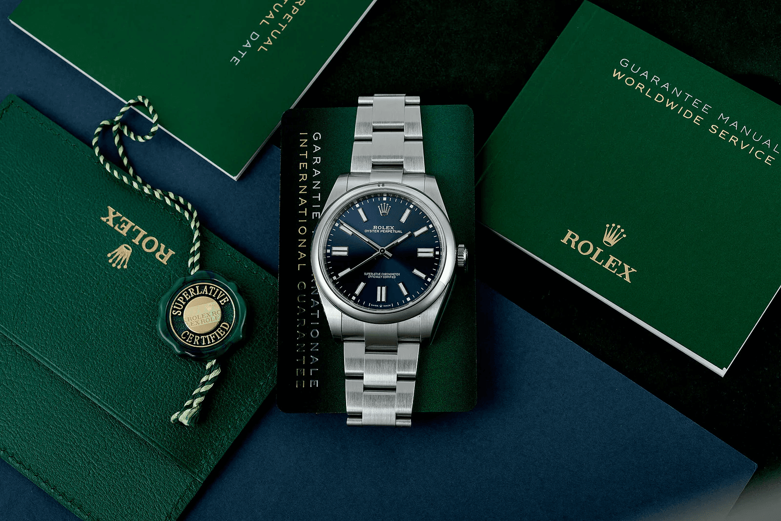 Rolex watch with original box, papers, and warranty card in a flat lay arrangement